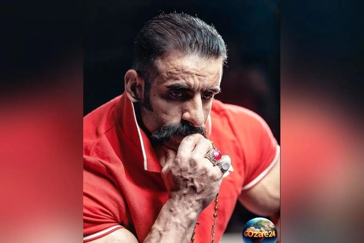 تصویر دیدنی از فیگور جذاب هادی چوپان با گوشی آیفون مقابل کتابخانه شخصی و دکور ایرانی اصیل + زندگی و افتخارات قهرمان ملی