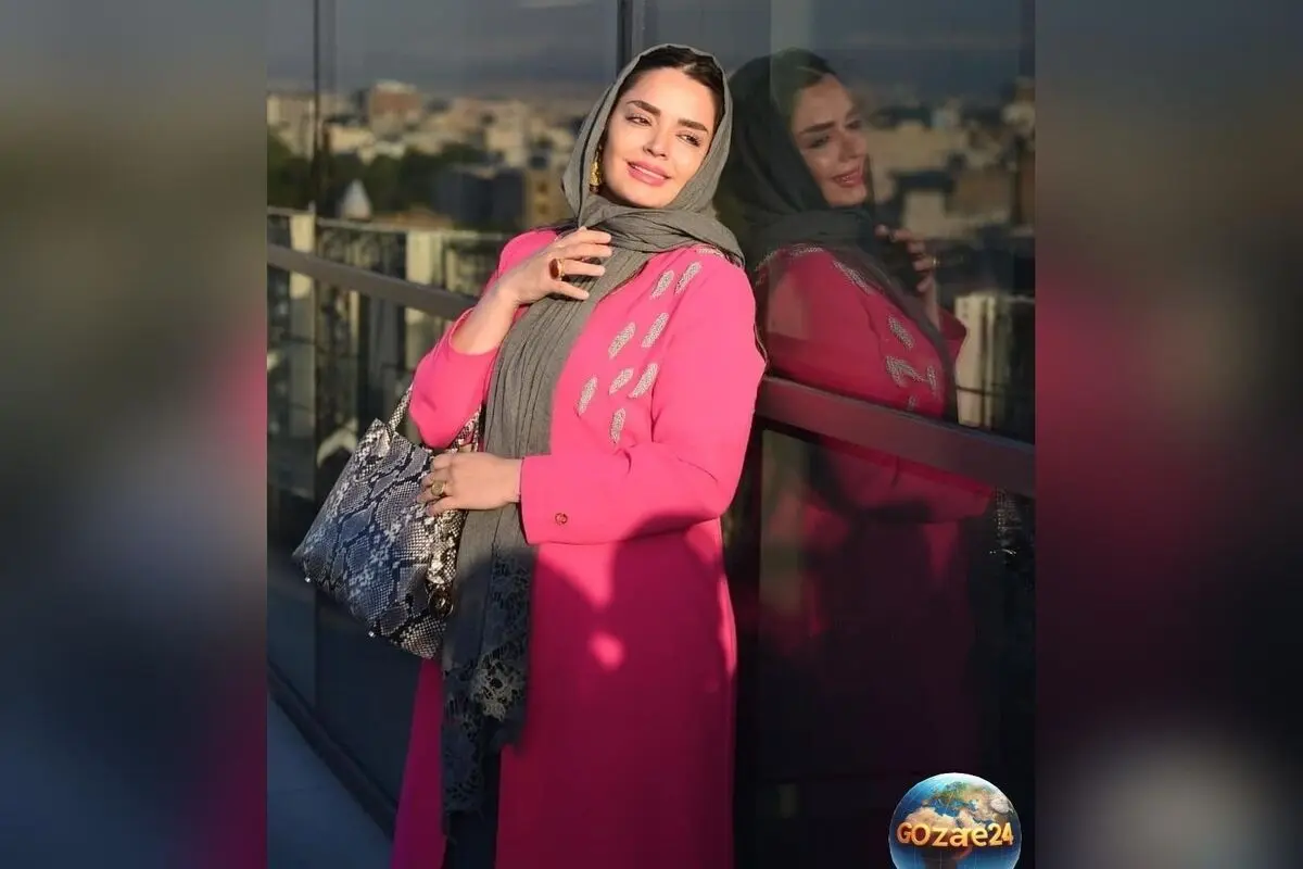 سپیده خداوردی در بابلسر با استایل قرمز رنگ پافر و هودی برای عکسی یادگاری در کنار دریا